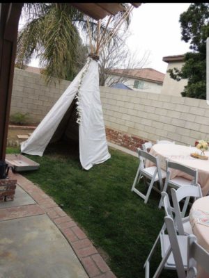 A Quinceañera celebration in a backyard with a teepee tent set up