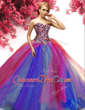 A woman in a colorful gown Quinceañera dress posing for a picture