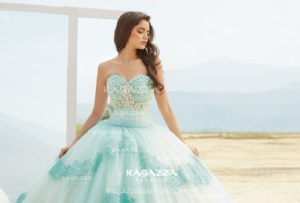 A woman in a ball gown standing on a beach, wearing a Quinceañera dress creation