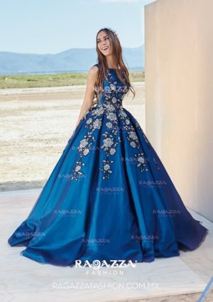 A woman in a blue gown poses for a picture in one of the Quinceañera dresses.