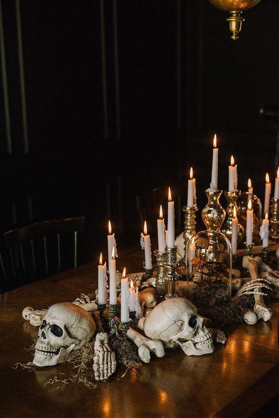 A spooky Quinceanera table decor with a wooden table adorned with skulls and candles