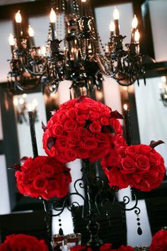 A Quinceanera-themed image featuring a flower bouquet and a black chandelier adorned with red roses and candles