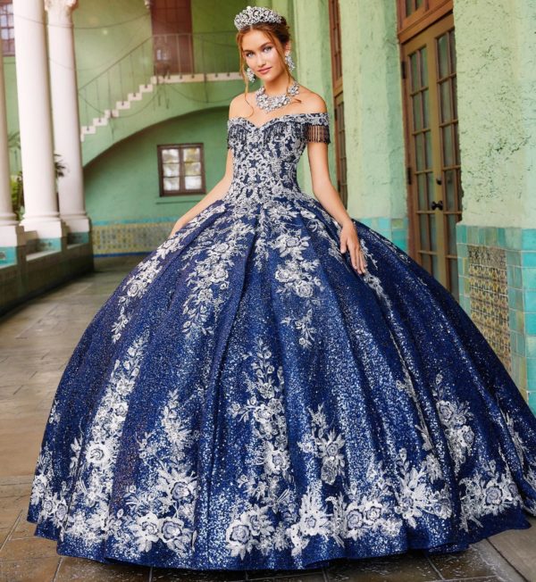 A woman wearing a navy blue and gold Quinceañera dress, a blue and white ball gown