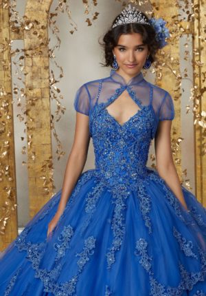 Quinceanera gown, a woman in a blue dress posing for a picture