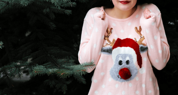 A girl wearing a pink Christmas sweater with a reindeer on it, celebrating Quinceanera
