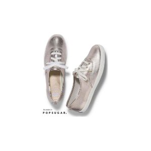 A pair of beige and silver Quinceanera shoes on a white background
