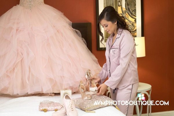 Quinceanera gown, a woman in a pink dress is putting on shoes