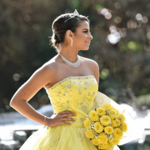 Quinceanera gown: A woman in a yellow dress holding a bouquet