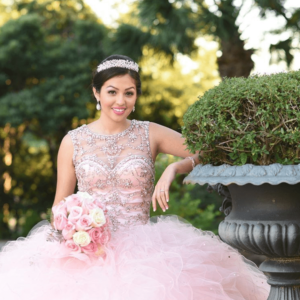 Floral design gown, a woman in a pink dress posing for a picture at a Quinceanera celebration
