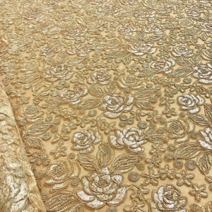 A close up of a lace tablecloth with flowers on it, perfect for a Quinceanera celebration.
