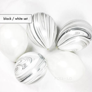 A group of marble balls sitting on top of a white surface with body jewelry Pantone