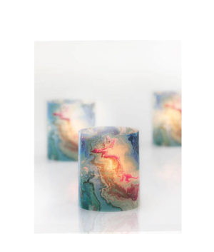 A couple of candles sitting on top of a table with wax Pantone