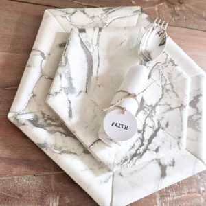 A marbled place setting on a wooden table, perfect for a Quinceanera celebration