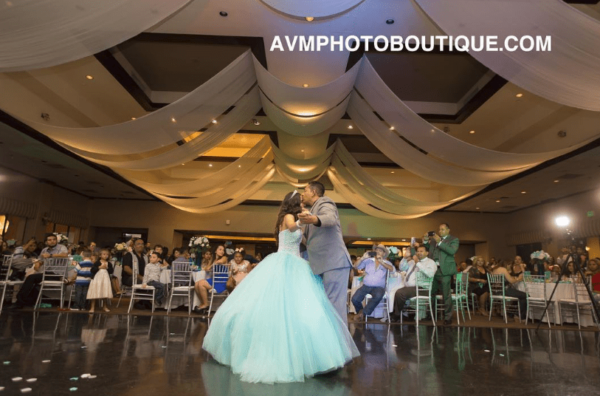 A photograph of a Quinceañera, with a man and a woman dancing in a ballroom