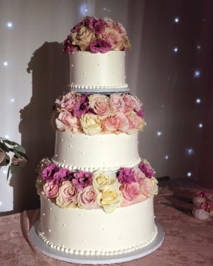 Quinceanera cake, a three tiered cake with pink and white flowers