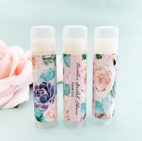 Three Quinceanera themed lip balms with floral designs on them