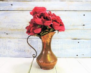 Floral design, a vase with red flowers in it on a table for a Quinceanera celebration