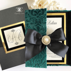 A close up of an emerald green Quinceanera invitation with a bow
