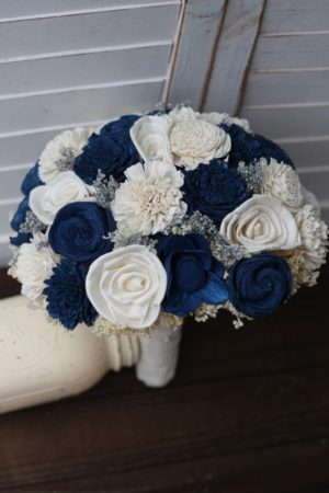 Quinceanera image: A dark blue and white flower bouquet arranged in a shoe