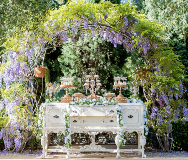 A Quinceañera themed garden spring table with a bunch of cakes on it