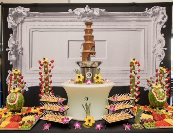 Quinceanera celebration with cake decorating and a table topped with lots of different types of food