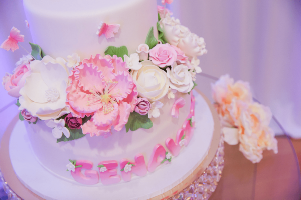 Quinceanera cake decorating with pink and white flowers on top