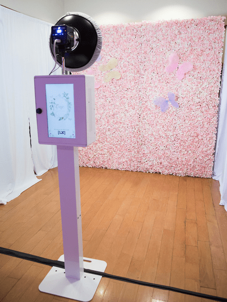 A Quinceanera-themed room with a floor design, featuring a fan and a pink wall