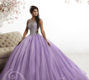 A woman in a lilac dress with gold Quinceanera dresses, posing for a picture in a purple ball gown