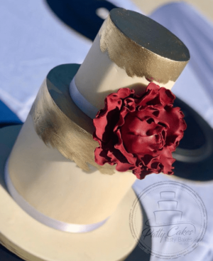 A close up of a Quinceanera cake with a flower on top