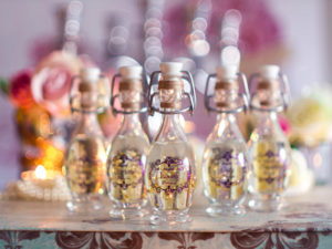 Quinceanera enchanted forest party favors, a group of small bottles filled with flowers