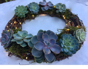 Floral design, a wreath of succulents and lights on a table for a Quinceanera celebration