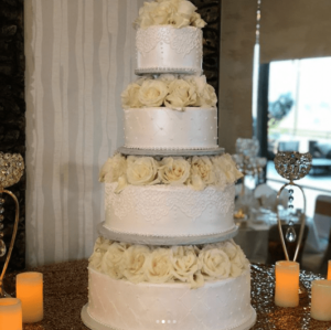 A three-tiered Quinceanera cake with white roses