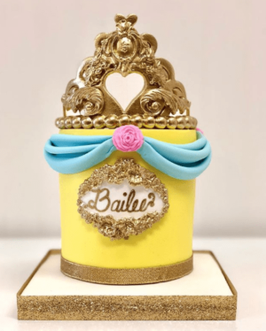 A Quinceanera cake with a crown on top of it