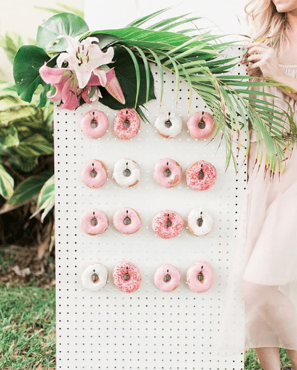 Flower bouquet Quinceañera standing in front of a display of donuts