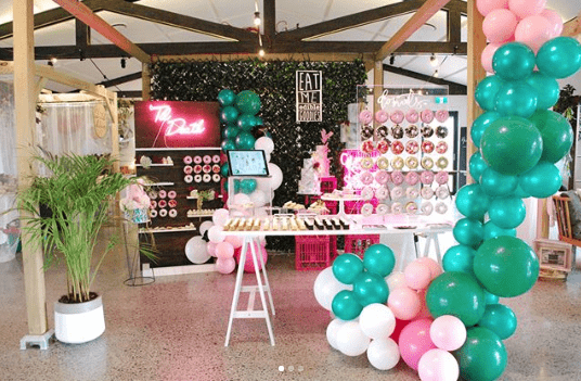 A vibrant Quinceanera party with a room filled with lots of balloons and decorations