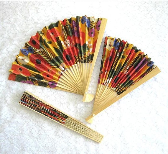 Quinceañera decorative fan: a group of colorful paper fans sitting on top of a white surface