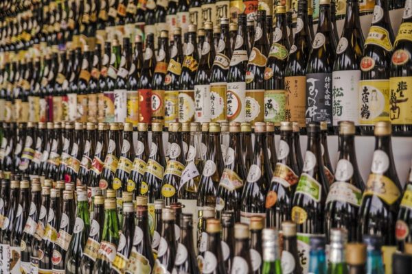 A wall full of bottles of different types and sizes of Quinceanera themed Sake