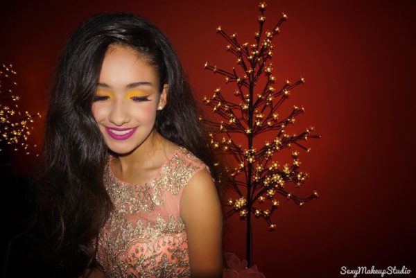 Quinceanera beauty, a woman with long black hair wearing a gold dress