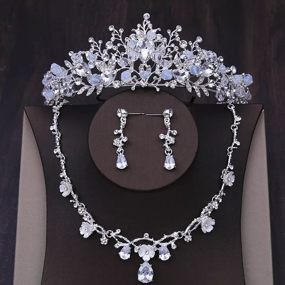 A Quinceanera crown and wedding accessories, including an earring, a necklace, and an earring set, on a mannequin