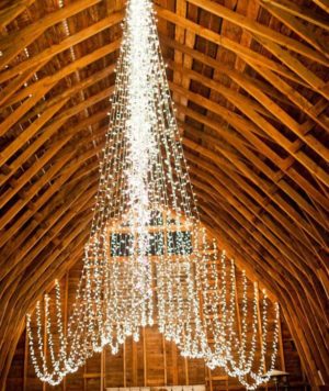 Quinceanera: A winter quinceanera alter idea with a barn setting and a chandelier hanging from the ceiling