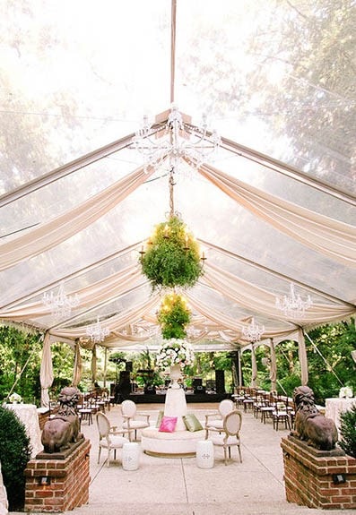 A Quinceanera gazebo with tables and chairs, adorned with a beautiful chandelier.