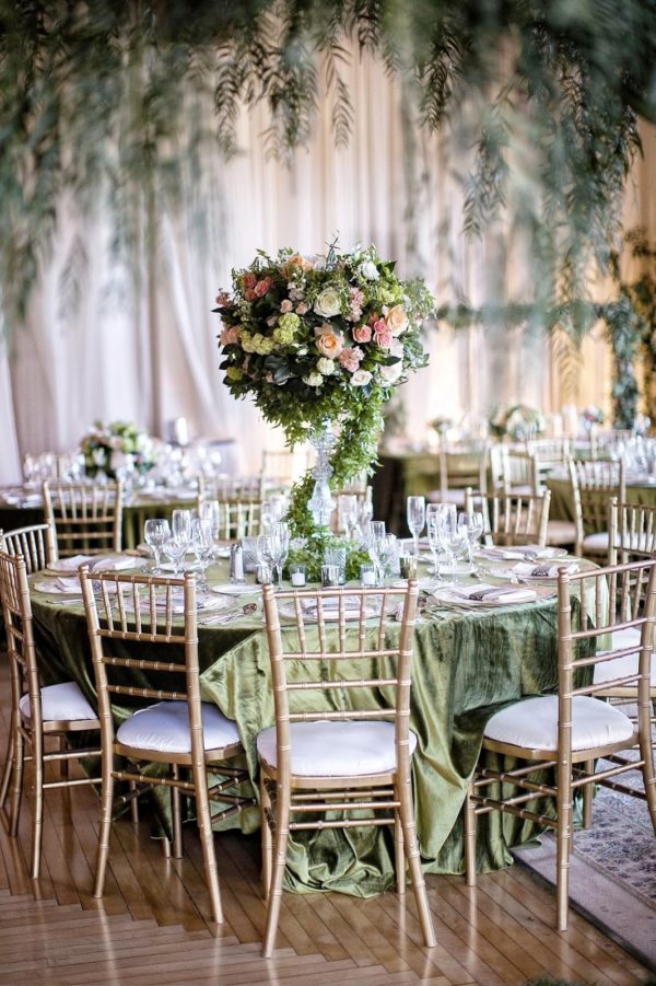 Quinceanera garden theme centrepiece: A table with a bunch of chairs and a vase with flowers on it
