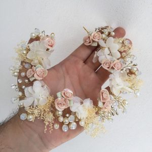 A person holding a flower crown in their hand with a Quinceanera jewellery Headpiece