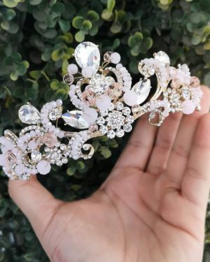 Quinceanera jewellery - A hand holding a tiara with pearls and crystals