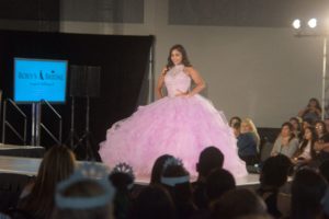 Quinceanera fashion show: Fashion design, a woman in a pink dress walking down a runway