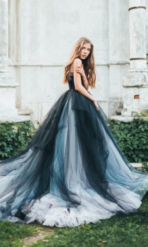 Quinceanera Dress, a woman in a black and blue dress standing in front of a building