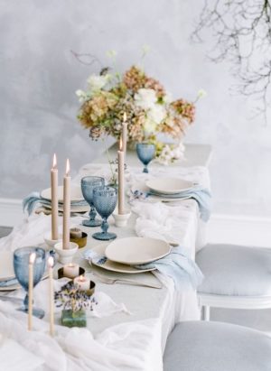 A Quinceanera table, featuring a dining table with a white tablecloth and blue chairs