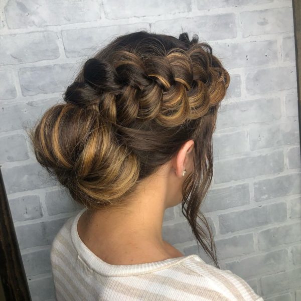 A woman with long hair in a messy bun, showcasing a Quinceanera hairstyle.