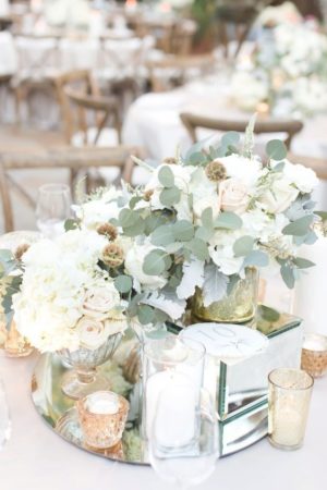 A Quinceanera centrepiece featuring a table adorned with white flowers and candles in a floral design