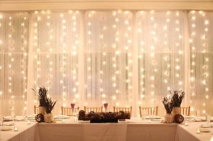 Quinceanera backdrop lighting and a dining room with a table covered in white tablecloths